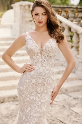 Fall in love all over again with this breathtaking mermaid gown. Featuring a sultry deep plunge bodice adorned with dreamy three-dimensional floral lace, this bridal style is ultra-flattering and divinely feminine. A showstopping chapel train with delicate shimmering sequin detail completes this stunning bridal style.