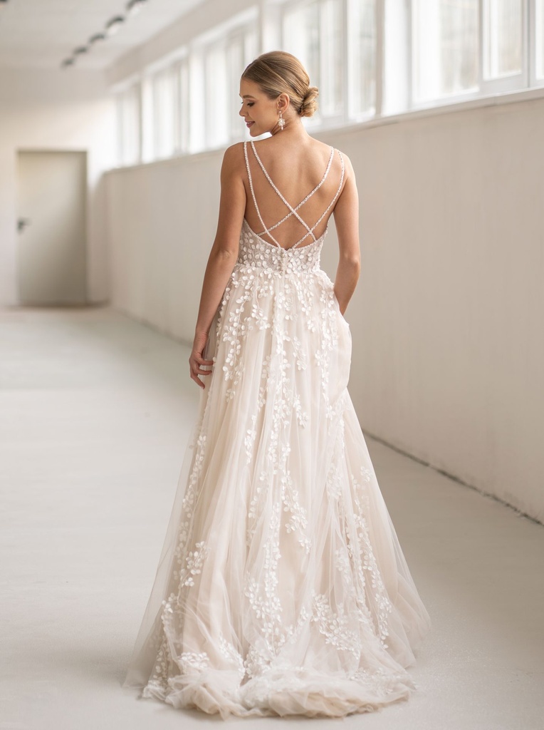This gown features delicate 3D leaf lace cascading from bodice to train, with fine beaded straps that create an elegant pattern across the back.